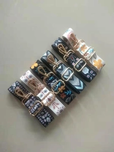 Detail of five adjustable floral and geometric patterned handbag straps with gold metal clips