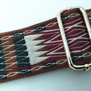 Detailed texture of ethnic embroidered strap with light gold metal adjustment buckle