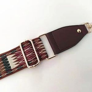 Close-up of geometric patterned shoulder strap with durable swivel hooks and hardware