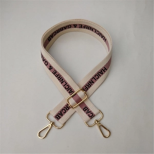 Adjustable canvas shoulder strap with purple stripe and black lettering and gold metal clips