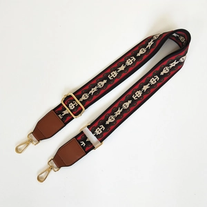 Close-up of wide ethnic stripe woven bag strap with adjustable gold metal buckle