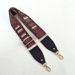 Close-up of adjustable ethnic geometric pattern shoulder strap with gold metal hooks