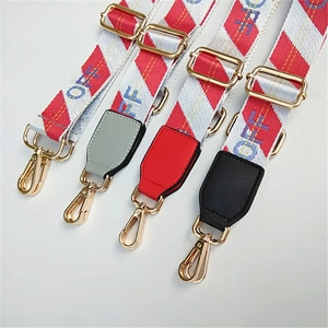 Detail of adjustable nylon straps with letter patterns and gold metal lobster clasps