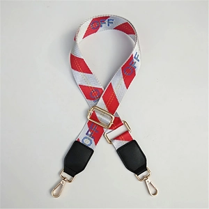 Close-up of adjustable striped bag strap with OFF text and gold metal hooks