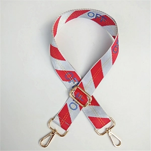 Detailed view of red and white striped canvas strap with blue lettering and gold buckle