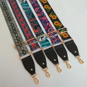 Detail of adjustable patterned bag straps with leather ends and golden metal clips