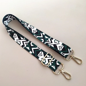 Detail of adjustable bohemian guitar strap with green geometric patterns and gold metal buckles