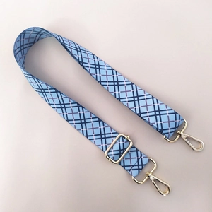 Detail of adjustable blue plaid bag strap with premium gold metal swivel hooks and buckles
