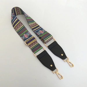 Detail of adjustable ethnic style bag strap with colorful woven pattern and gold hooks