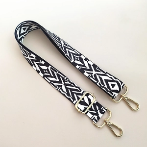 Detail of adjustable black and white geometric woven strap with gold metal lobster clasps