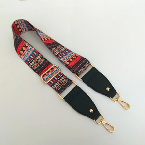 Detail of ethnic geometric wide bag strap with gold lobster clasps and black leather ends