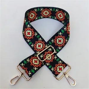 Detail of adjustable ethnic wide bag strap with colorful geometric patterns and gold buckle