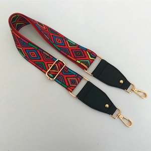 Close-up of ethnic woven bag strap with colorful geometric patterns and gold metal clips
