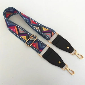 Detail of colorful geometric woven strap with gold metal hooks and black leather ends