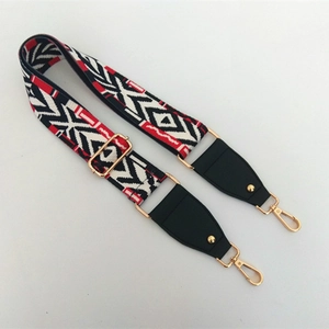 Close-up of adjustable ethnic bag strap with red, black, and white geometric patterns