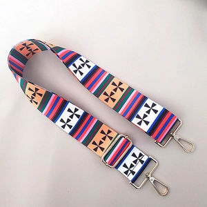 Macro detail of adjustable colorful ethnic pattern bag strap with gold metal hooks