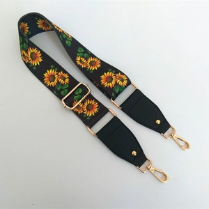 Detail of adjustable bag strap with sunflower print and gold metal swivel snap hooks