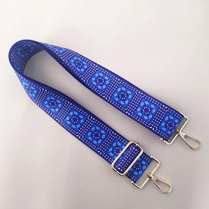 Close-up of ethnic geometric pattern strap with silver adjustable metal hardware