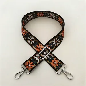 Detalle de correa bordada bohemia con hebilla ajustable y ganchos de metal plateado