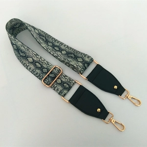 Detail of adjustable wide guitar strap with grey snake print and gold metal hooks