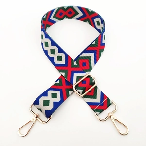 Detail of adjustable colorful woven strap with ethnic geometric patterns and gold metal clips