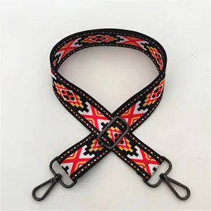 Detalle de correa étnica para bolso con diseño jacquard y ganchos metálicos ajustables