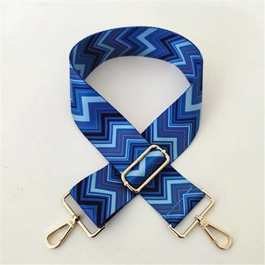 Close-up of adjustable woven chevron strap with gold-tone metal buckles in blue and black