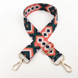 Detail of colorful geometric canvas strap with premium light gold metal hardware