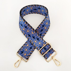 Detail of blue nylon jacquard strap with gold geometric patterns and metal buckles
