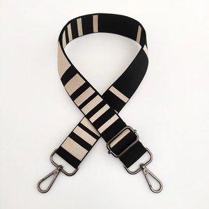 Detail of adjustable wide striped shoulder strap with gunmetal swivel hooks for bags
