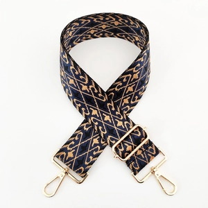 Close-up of geometric jacquard wide shoulder strap with golden metal swivel hooks