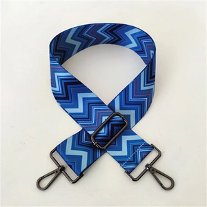 Detail of adjustable woven bag strap with blue zigzag pattern and metal lobster hooks