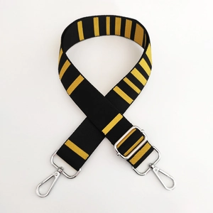 Close-up of adjustable striped canvas bag strap with silver metal hooks and buckle