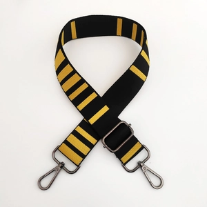 Detail of adjustable black and yellow striped bag strap with dark metal swivel hooks
