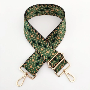 Close-up of vintage wide woven bag strap with golden diamond patterns and metal hooks