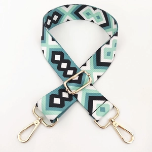 Close-up of colorful geometric woven bag strap with golden metal lobster clasps