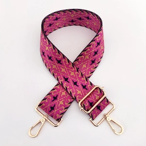 Detail of colorful geometric embroidery on wide adjustable shoulder strap with gold hardware