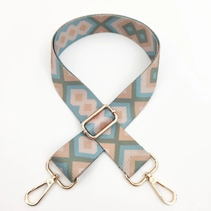 Detail of colorful geometric pattern bag strap with gold metal swivel hook and buckle