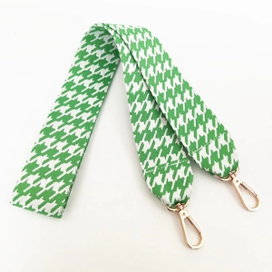 Detail of green and white houndstooth shoulder strap with gold metal swivel clasps