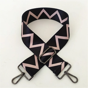 Close-up of adjustable wide woven bag strap with pink zigzag patterns and metal hardware