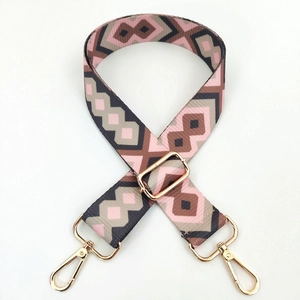 Close-up of geometric ethnic pattern bag strap with gold metal swiveling clasps