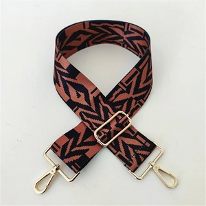 Close-up of wide adjustable woven bag strap with orange and black geometric pattern