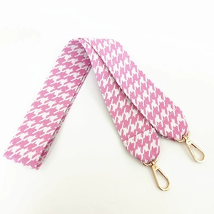 Macro detail of pink houndstooth cotton bag strap with premium gold alloy swivel hooks