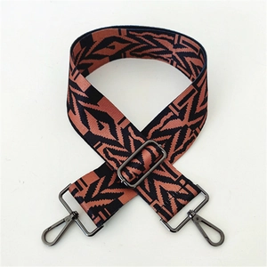 Close-up of geometric jacquard shoulder strap with gunmetal swivel hooks and slider