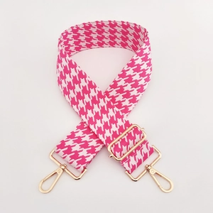 Detailaufnahme des rosa-weißen Hahnentritt-Taschenriemens mit goldfarbenen Metallkarabinern