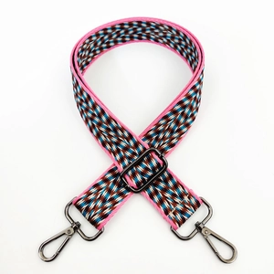 Detail of colorful woven geometric bag strap with dark grey metal swivel hooks