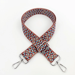 Close-up of colorful woven jacquard shoulder strap with vintage ethnic pattern and metal clips