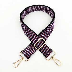 Detail of adjustable woven jacquard strap with red and blue chevron pattern and gold metal hooks