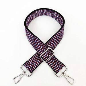 Detail of colorful woven shoulder strap with zigzag pattern and silver metal buckle