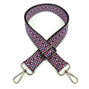 Macro detail of red, blue, and white woven crossbody strap with metallic lobster clasp